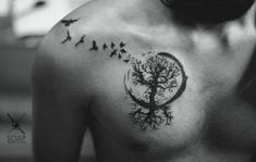 a man with a tree and birds tattoo on his back