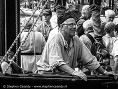 an old black and white photo of a man on a boat surrounded by other people