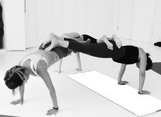 two women are doing yoga on mats in a room with white walls and flooring