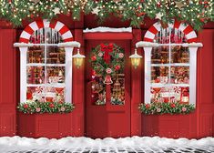 two red doors decorated with christmas decorations and wreaths in front of a storefront