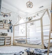 a room with two beds and some shelves on the wall next to each other in front of a window