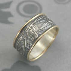 Fleur Nouveau Wide Band Floral Ring Art Nouveau Ring Art Deco Band Wide Wedding Ring Two Tone Band Flower Ring Wide Patterned Band Gold Ring Materials: 14K Gold, Sterling Silver Dimensions: 9.5mm wide by approximately 1.25mm thick This stunning Art Nouveau style band is hand made in our studio from solid Sterling Silver patterned stock. It is embossed around the entire surface with a lovely swooping floral motif. We expertly add a 1mm wide round 14K Gold edge to each side, bringing the overall w Art Deco Band, Wide Wedding Rings, Art Nouveau Ring, Flower Band, Platinum Wedding, Floral Ring, Etsy Gold Ring, Ring Art Deco, Wide Bands