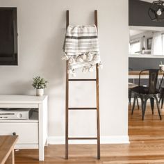 a towel rack in the corner of a room with a table and chairs behind it