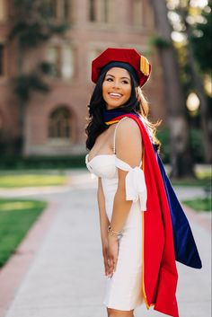 a woman wearing a red, white and blue graduation gown is posing for a photo