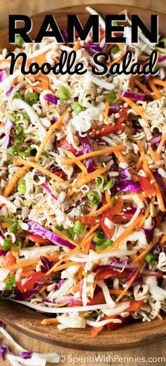 a wooden bowl filled with coleslaw slaw and topped with shredded carrots