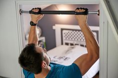 a man is lifting up the bar in his bedroom