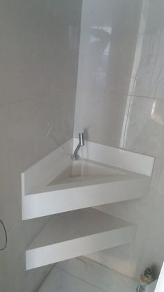 a white bathroom sink sitting under a mirror next to a wall mounted faucet