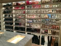 there are many pairs of shoes on display in the store's walk - in closet