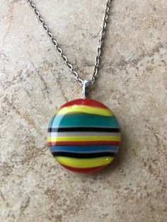 "This is a fun colorful sunny summer striped fused glass pendant necklace, with opalescent and transparent glass in red, teal, yellow, black and pink. The pendant is 1.00\" x 1.00\" and comes on a 16\" chain with lobster clasp. Caring for fused glass jewelry: To clean, use a soft cloth. Do not use harsh chemicals to clean. Should not be submerged in water, and should be removed when bathing. While fused glass is much stronger, use care when handling as can still break if dropped on hard surface. Multicolor Recycled Glass Necklaces For Gifts, Multicolor Recycled Glass Necklace As Gift, Multicolor Glass Round Pendant Necklace, Fused Glass Pendant Necklace, Fused Glass Necklace, Teal Yellow, Fused Glass Pendant, Fused Glass Jewelry, Summer Stripes