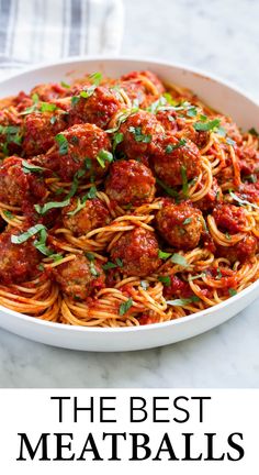 the best meatballs recipe with spaghetti and parsley in a white bowl on a marble countertop