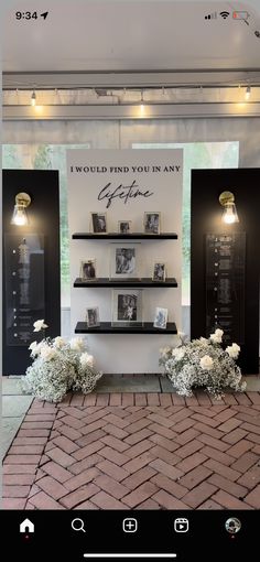 an image of a display with flowers and pictures on the wall in front of it