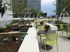 an outdoor seating area with tables, chairs and couches in the middle of it