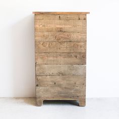 an old wooden dresser sitting against a white wall