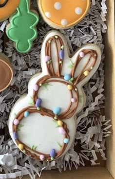 decorated cookies in an open box with frosting and decorations on it's sides