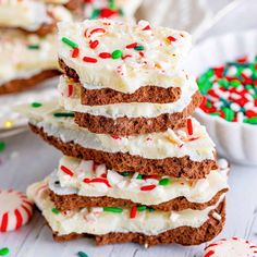 a stack of cookies with white frosting and sprinkles next to candy canes