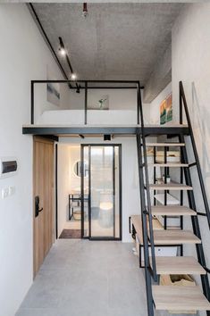 the stairs lead up to the bedroom and bathroom in this modern loft style home, which also has an open floor plan