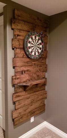 a wooden wall mounted to the side of a wall with a dart on top of it