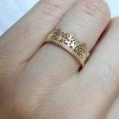 a close up of a person's hand with a gold ring on their finger