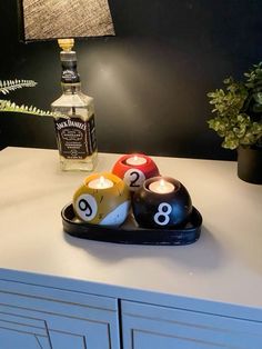 three pool balls sitting on top of a counter next to a bottle of booze