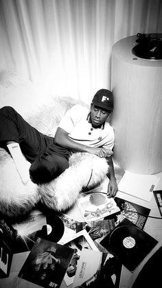 a man sitting on top of a white couch next to a lamp and record player