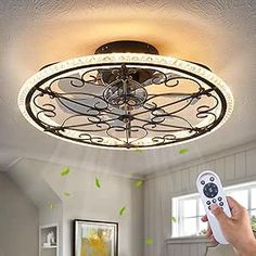 a person holding a remote control up to a ceiling light in a room with white walls