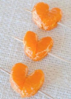 three oranges shaped like hearts sitting on a table