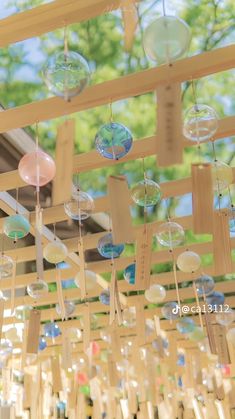 the inside of a building with many bubbles hanging from it's ceiling and some trees in the background