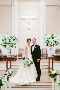 a bride and groom pose for a photo in front of the alter at their wedding