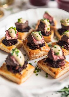 small appetizers are arranged on a plate with garnishes and herbs