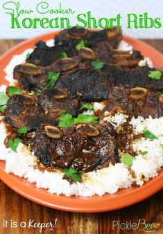 an orange plate topped with meat and rice on top of a wooden table next to a green sign