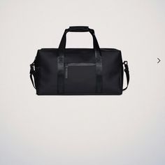 a black duffel bag sitting on top of a white wall