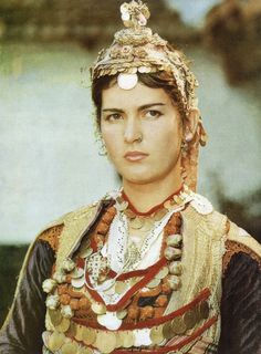 a woman wearing an elaborate headdress and jewelry