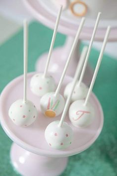 cake pops are sitting on a pink plate