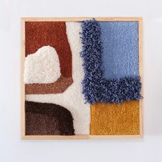 a wooden frame with several different colored rugs on top of it and a white wall in the background