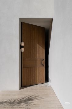 an open door in a white wall with light coming through it and shadows on the floor