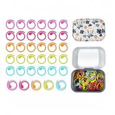 several pairs of colorful plastic rings in a tin with floral designs on the top and bottom