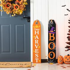 two halloween decorations sitting next to each other near a door with the words happy harvest on it