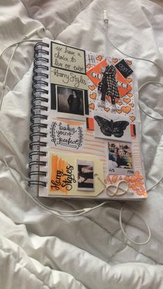 an open notebook with pictures and writing on it sitting on top of a white sheet