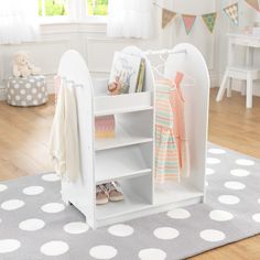 a child's book shelf with shoes and books on it in a room decorated with polka dots