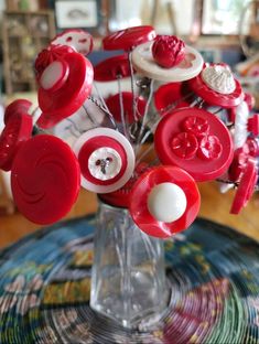 a vase filled with lots of red and white buttons