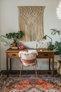 a room with a desk, chair and rug in front of a wall hanging on the wall