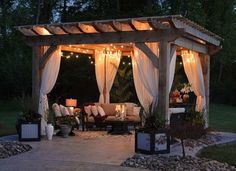 a gazebo with curtains and lights on it