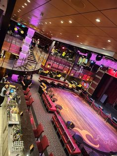 the inside of a restaurant with tables and red chairs, lights in the ceiling and people eating