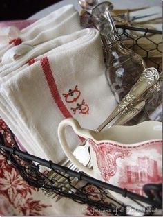 a basket filled with dishes and utensils on top of a table