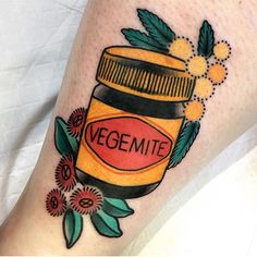 a woman's leg with a jar of vegemite on it and flowers