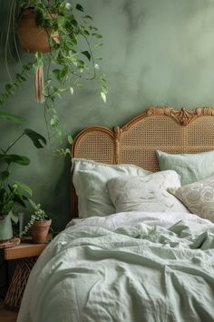 a bed with white linens and green plants on the headboard in a bedroom