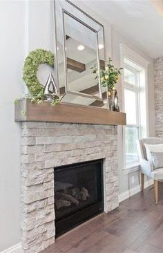 a living room filled with furniture and a fire place in front of a mirror on the wall