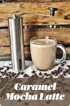 caramel mocha latte in a glass mug next to a coffee grinder