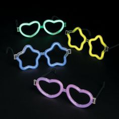 neon glasses with heart shaped frames are shown in different colors and shapes, all on a black background