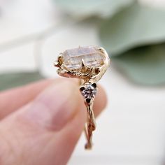 "An elegant emerald cut gold rutilated quartz gives this ring a unique, eye-catching appeal. The quartz is framed by two brilliant cut diamonds. Real-life budding twigs are used to transform her favorite precious metal into a whimsical band full of rustic texture. The twig band comes in solid 14K white gold, yellow gold or rose gold. Made to order, this ring is my original design and ships in 4 to 8 weeks. Sizes 3 to 10. Any questions, please feel free to contact me because I want her to love it Ethereal Diamond Rings For Gifts, Herkimer Diamond Jewelry With Rose Cut For Gift, Herkimer Diamond Wedding Jewelry, Gold Emerald Cut Engagement Ring, Rustic Engagement Rings, Contour Ring, Montana Sapphire Ring, Twig Engagement Ring, Nature Inspired Engagement Ring